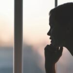 Image showing a woman contemplatively looking out the window.